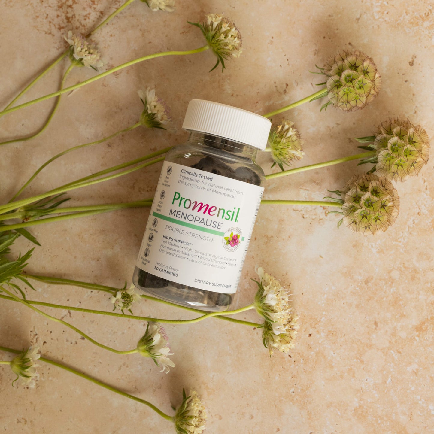 Promensil Menopause Double Strength Gummies bottle on flowers